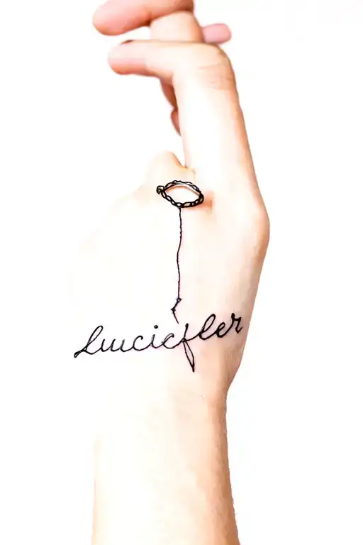 a thread forming the shape of a ring on the wedding ring finger and connected to the word "lucifer" on the wrist tattoo design idea