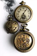 2 antique stop watches with lots smoke and metal gears tattoo design idea