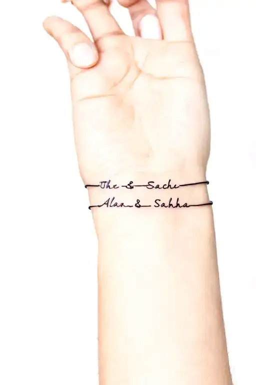 unclosed forearm bracelet with written the first names Alan and Sacha tattoo design idea