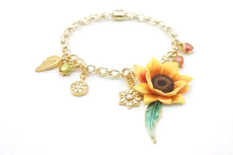charm bracelet with sunflower charm, bear emoji charm, diamond ring charm, virgo sign  charm, cancer sign charm, crown  tattoo design idea