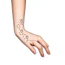 A hand tattoo with small teddy bears, a path of stars and dots that go up to the wrist tattoo design idea