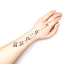A hand tattoo with small teddy bears, a path of stars and dots that go up to the wrist tattoo design idea