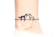 two wolves fine line around ankle bracelet tattoo design idea